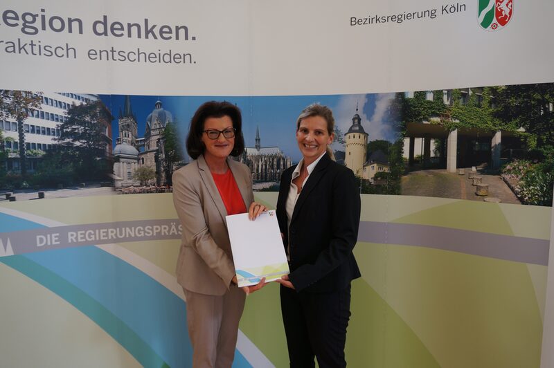 Gisela Walsken und Bürgermeisterin Marion Schunck-Zenker halten gemeinsam eine Urkunde in der Hand